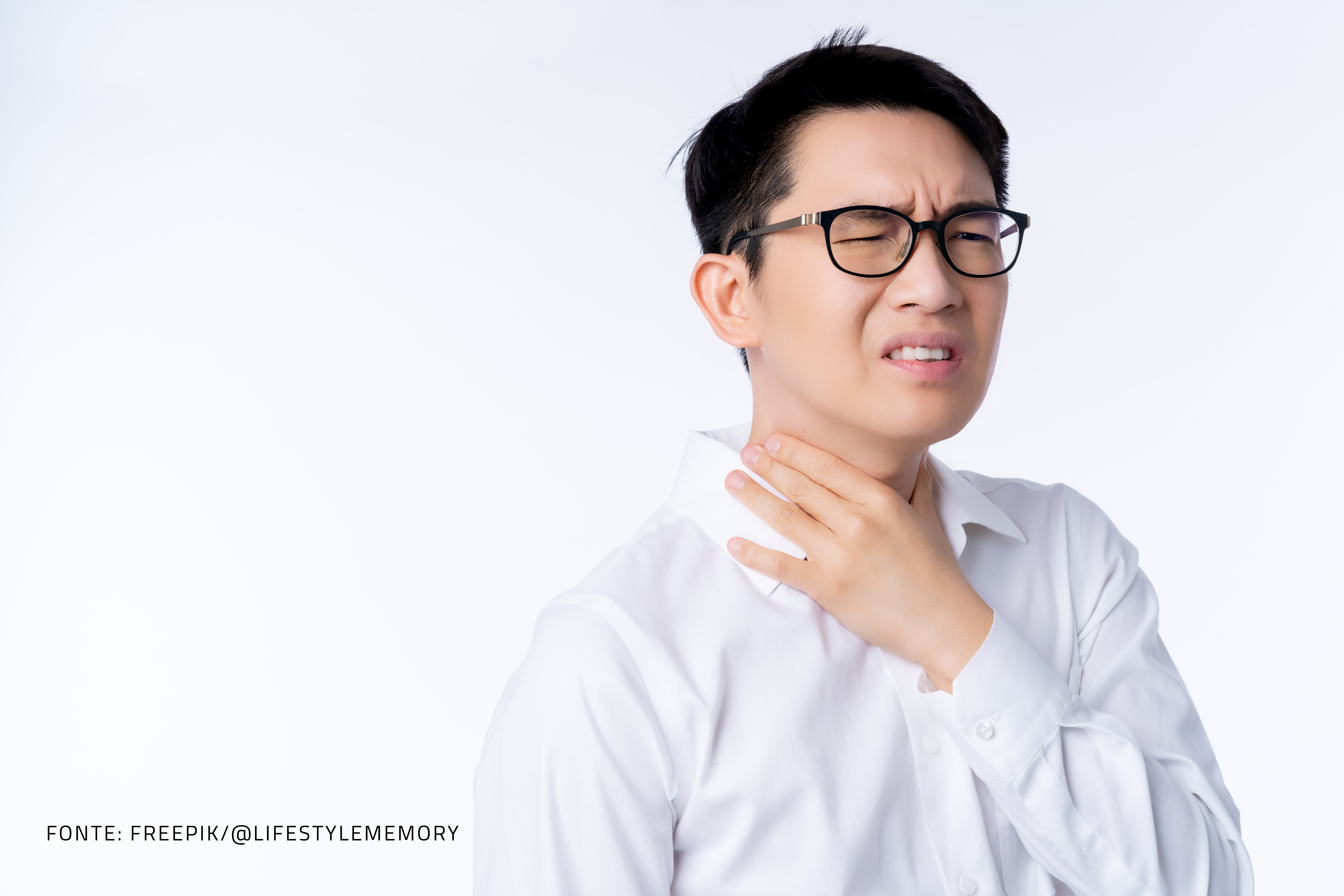 homem asiático com dor de garganta, usa camisa branca e óculos com armação preta.